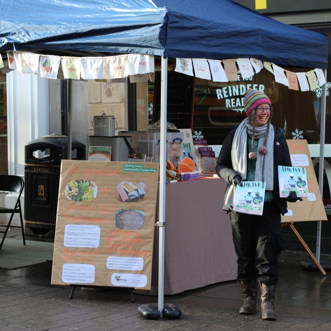 Person handing out magazines at FoodFutures market stall
