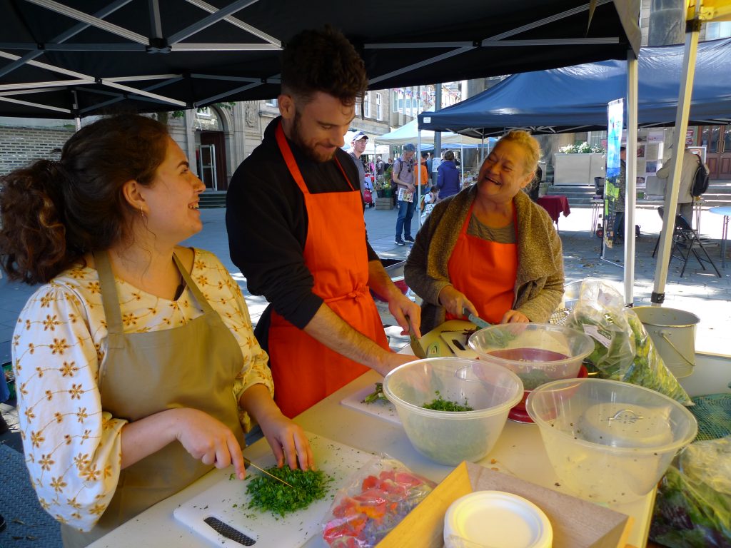 A photo of three people cooking at a market stall